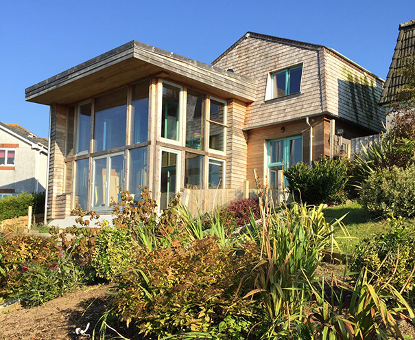 Wadebridge Responsive Home interior looking out through the sun-space from the upper floor.